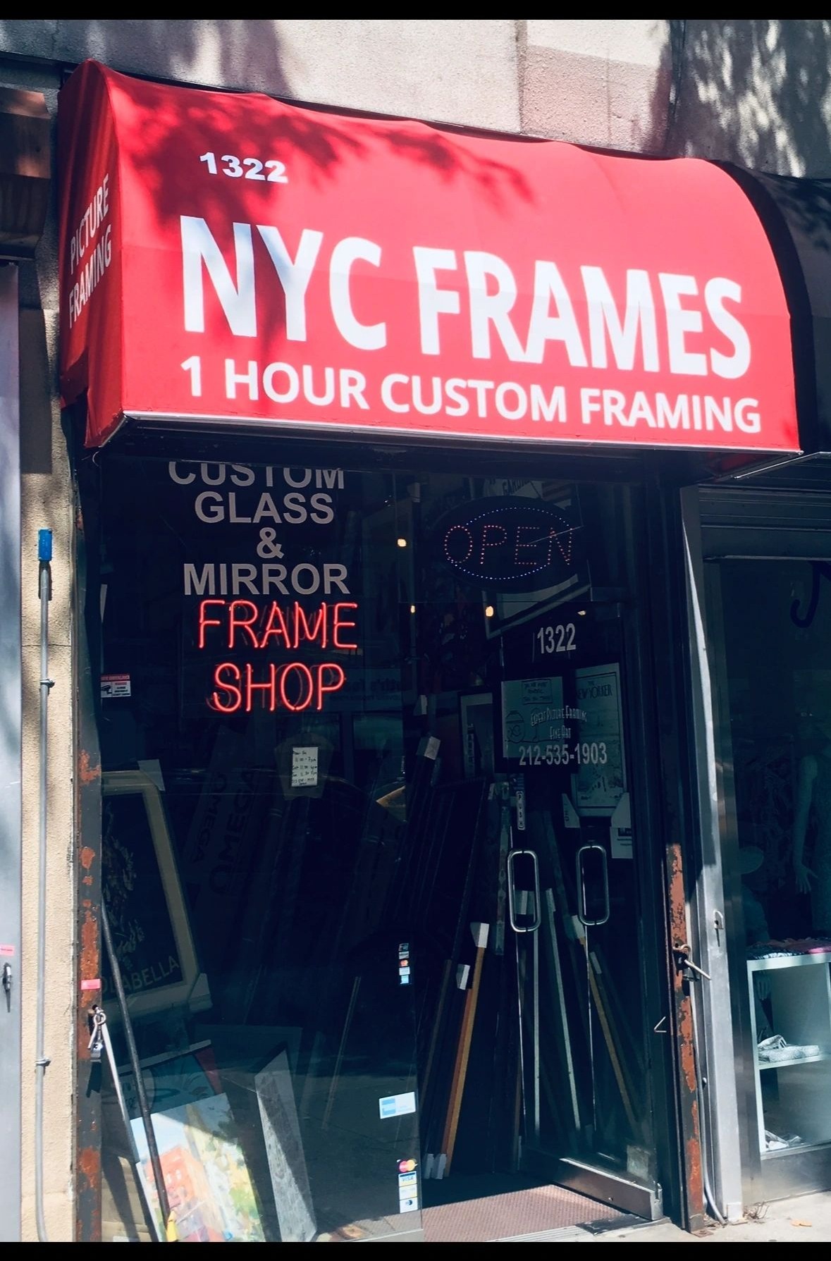 The NYC FRAMES storefront at 1322 3rd Avenue, with its red awning reading one hour custom framing
